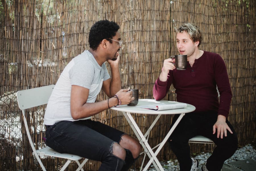 Two friends chatting over coffee outdoors
